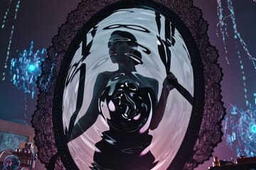Artistic workshop in amber and magenta tones, glowing keyboards crafting lingerie mirror prompts into boudoir AI video animations