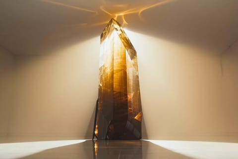 Dramatic 3D render of a glowing figure illuminated by shifting colorful beams in a dark studio.